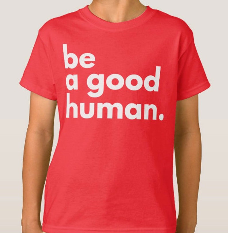 May include: Red t-shirt with white text that reads "be a good human."