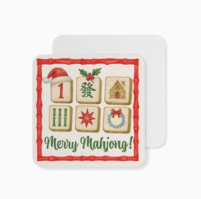 Puede incluir: Posavasos cuadrado con borde de bamb&uacute; rojo y el texto "Merry Mahjong!". El posavasos presenta ilustraciones de fichas de Mahjong, incluyendo un gorro de Pap&aacute; Noel, una casa y una corona. Un segundo posavasos es visible.