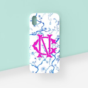 May include: A white phone case with a blue and white floral pattern and a pink monogram "NG".