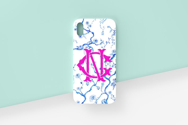 May include: A white phone case with a blue and white floral pattern and a pink monogram "NG".