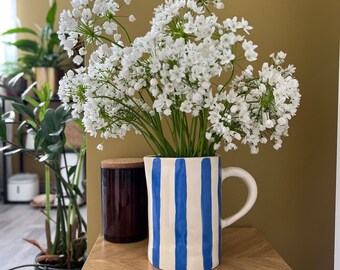 Handmade ceramic pitcher with blue stripes