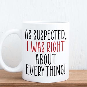 May include: White ceramic coffee mug with black text that reads "As suspected, I was right about everything!" The text "I was right" is in red.