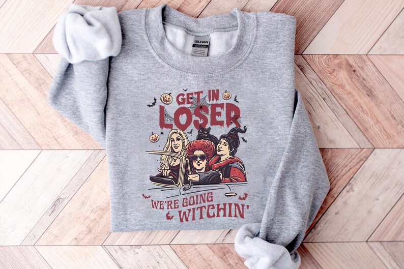 May include: Gray sweatshirt with a graphic of three women dressed as witches driving in a car. The text on the sweatshirt reads "Get in Loser, We're Going Witchin'"