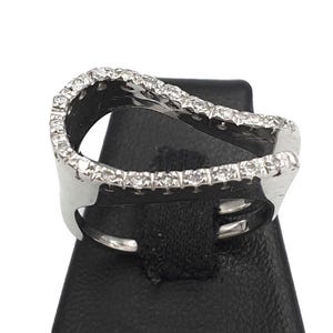 May include: A silver ring with a wavy design and a row of small diamonds around the edge.