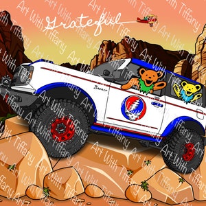 May include: A white Ford Bronco with a blue and red stripe design. The car has a Grateful Dead skull and roses sticker on the side and two cartoon bears in the windows. The car is driving on a rocky dirt road with a sunset in the background.
