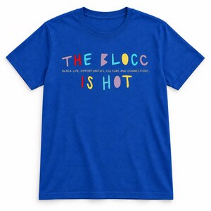 Op de afbeelding: Een koningsblauw t-shirt met korte mouwen voorzien van de meerkleurige tekst THE BLOCC IS HOT en de kleinere witte tekst BLACK LIFE, OPPORTUNITIES, CULTURE AND CONNECTIONS op het midden van het kledingstuk.
