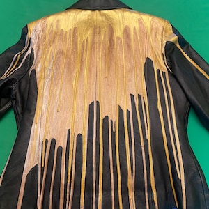 Drip Custom, Unisex Gold Paint Pour on Black Leather Jacket.  Labeled Wilson&#39;s Leather Women&#39;s Large.  Paint is authentic, not printed.