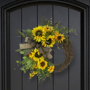 The sunflower wreath reach shown hanging on a black door.

This item measures measures 26 inches wide x 30 inches and is approximately 7 inches deep..