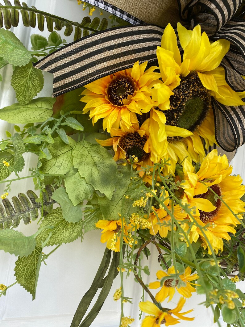 Close up of sunflowers and greenery included in the lower portion of wreath.