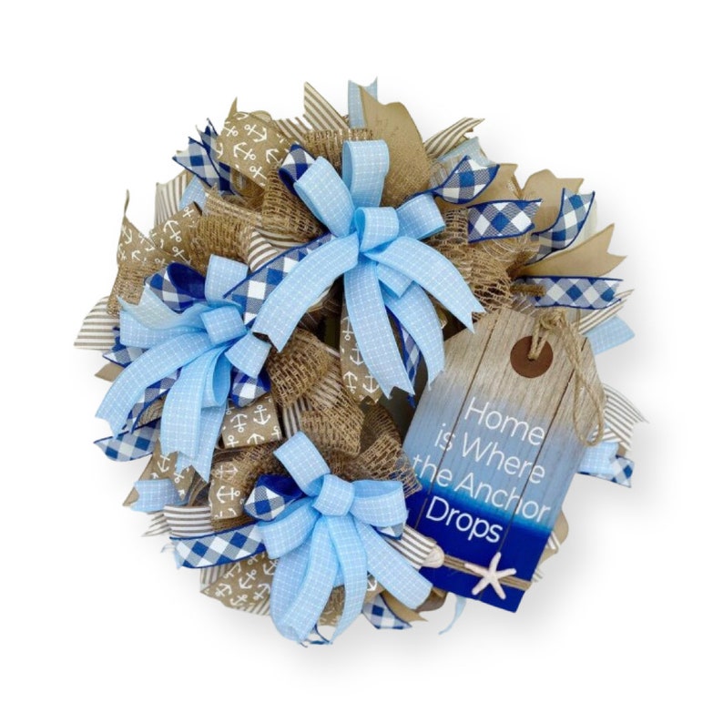 Large boating theme wreath designed with your lake or beach house in mind.  The perfect summer theme for a cabin or cottage, this wreath features a “Home is where the anchor drops” sign and includes the colors of sand and cool, inviting water.