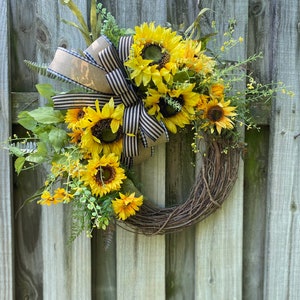 Wreath shown hanging on weathered wooden fence.
