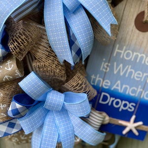 Additional close up of the wreath displayed on weathered wooden fence. This item would be a standout on a rustic door porch or patio.