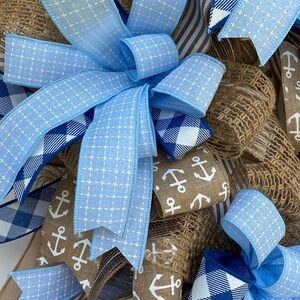 Close up of one of the three wreath bows. All feature 5 ribbons including various coordinating colors of blue mixed with several that are khaki colored.