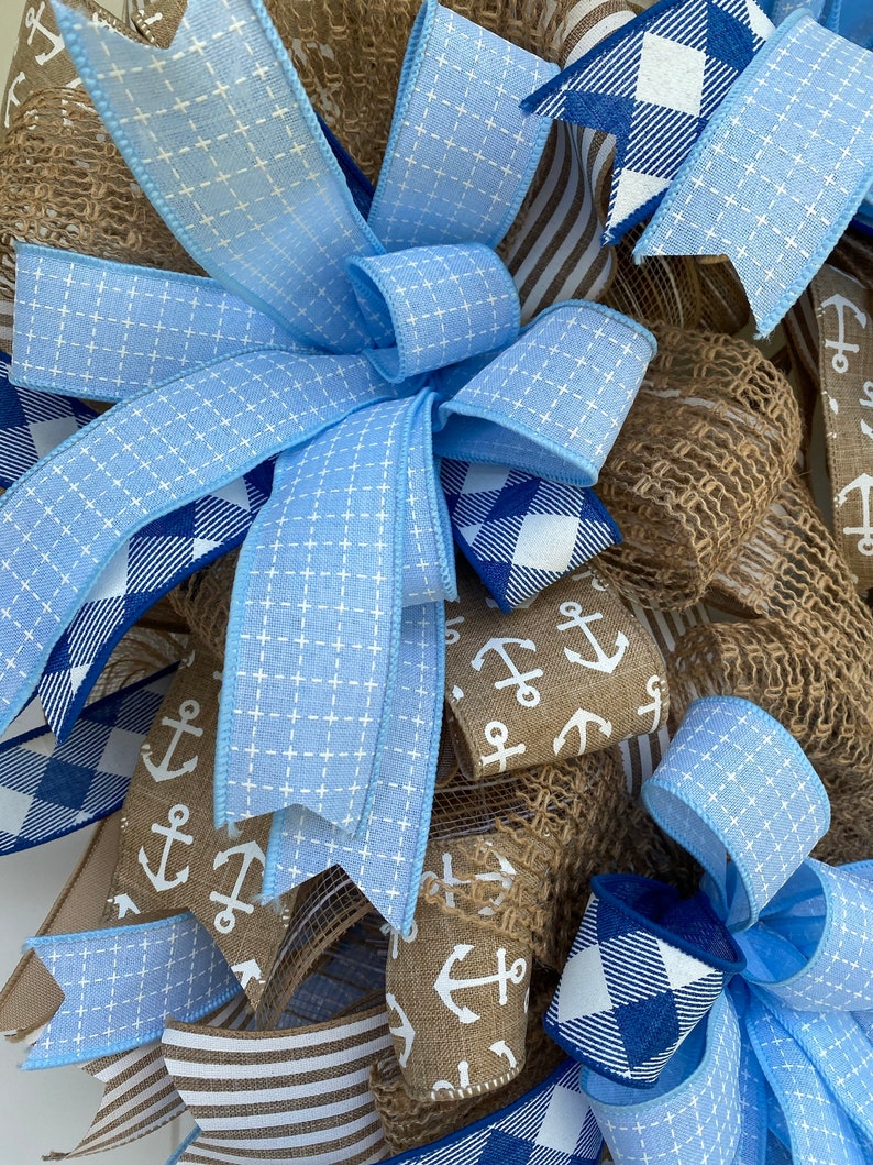 Close up of one of the three wreath bows. All feature 5 ribbons including various coordinating colors of blue mixed with several that are khaki colored.