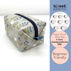 May include: A rectangular boxy bag with a floral pattern in shades of gray, green, and blue. The bag has a navy blue zipper and a small fabric loop on one end. The image also includes a graphic with text: "Zipper Pouch Boxy Bag 8 Sizes Sewing patterns PDF".