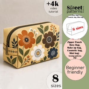 Könnte beinhalten: Ein rechteckiges, kastenförmiges Etui mit beigefarbenem Grund und einem Blumenmuster in Orange, Weiß, Dunkelbraun und Marineblau mit grünen Blättern. Das Etui verfügt über einen dunklen Reißverschluss und eine seitliche Lasche mit floralem Aufdruck.