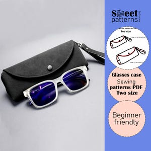 May include: A pair of clear-framed eyeglasses with blue lenses rests beside a dark gray glasses case. The case has a snap closure and a wrist strap. The image also includes text that says "Glasses case Sewing patterns PDF Two size Beginner friendly."