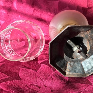 May include: A vintage glass lampshade with a frosted glass globe and a black metal base. The base has a hexagonal shape and a metal arm with a screw.