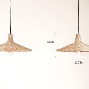 K&ouml;nnte beinhalten: Zwei nat&uuml;rliche geflochtene Weiden-Pendelleuchten mit schwarzen Kabeln, die von der Decke h&auml;ngen. Jede Leuchte ist 17,7 Zoll breit und 7,8 Zoll hoch.