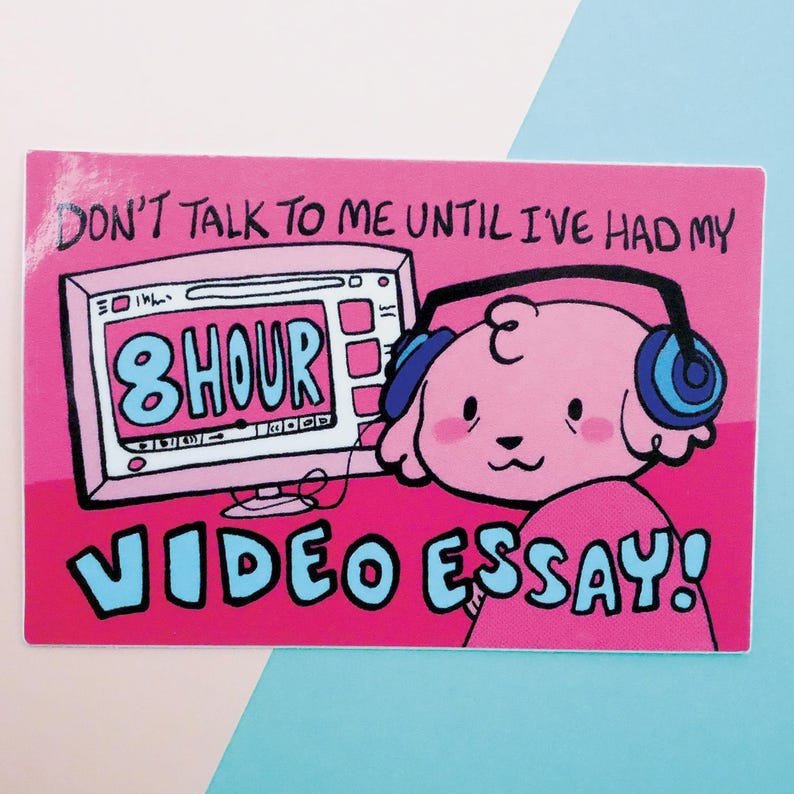 May include: Pink cartoon dog wearing headphones in front of a computer screen that says "8 hour video essay!" and the text "Don't talk to me until I've had my 8 hour video essay!"