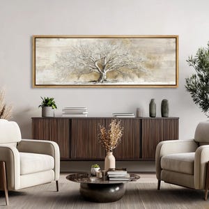 May include: A framed canvas art piece featuring a detailed, textured depiction of a large tree with white branches against a neutral, beige background. The artwork is encased in a gold-colored frame, suitable for home decor.