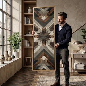 May include: Geometric wooden wall art with a gold frame. The artwork features a starburst design in shades of brown, gray, and white. The piece is rectangular and appears to be made of various wood pieces arranged in a pattern.