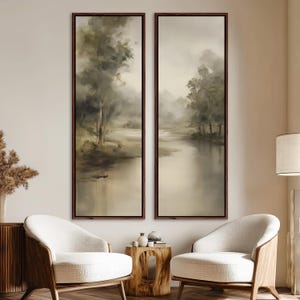 May include: Two framed landscape paintings depict a serene river scene with trees and soft, muted colors. The artwork features a blend of greens, browns, and beige tones, creating a calming atmosphere. The frames are a dark brown, adding a touch of elegance to the wall art.