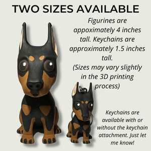 May include: Two sizes of a black and brown Doberman Pinscher figurine. The larger figurine is approximately 4 inches tall and the smaller figurine is approximately 1.5 inches tall.  The text "TWO SIZES AVAILABLE" is at the top of the image.  The text "Figurines are appoximately 4 inches tall. Keychains are approximately 1.5 inches tall. (Sizes may vary slightly in the 3D printing process) Keychains are available with or without the keychain attachment. Just let me know!" is on the right side of the image.