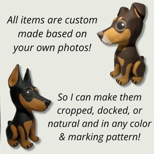 May include: Two custom-made dog figurines, one black and tan and one brown and tan, are sitting on a white background. The text "All items are custom made based on your own photos! So I can make them cropped, docked, or natural and in any color & marking pattern!" is written below the figurines.