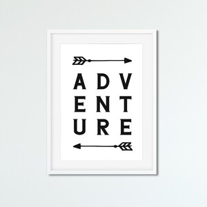 May include: A framed print with the word "ADVENTURE" in bold black letters. Two black arrows, one above and one below the word, point to the right. The print is in a white frame.