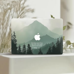Puede incluir: Funda para portátil con un paisaje montañoso brumoso en tonos verdes y grises. Muestra un logotipo de Apple blanco y el texto "My help comes from the Lord, who made heaven and earth. Psalm 121:2."