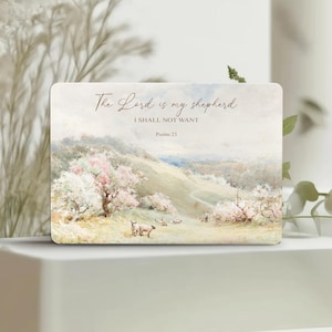 May include: A rectangular sign featuring a pastoral landscape painting with rolling hills, blooming trees, and sheep. The text reads: The Lord is my shepherd, I SHALL NOT WANT, Psalm 23. The color palette includes soft greens, creams, and pinks.