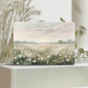 May include: A rectangular sign featuring a soft-toned landscape painting of a field of white daisies under a pale sky. The text "I HAVE SEEN THE goodness of God" is printed in a dark script font across the upper portion of the image.
