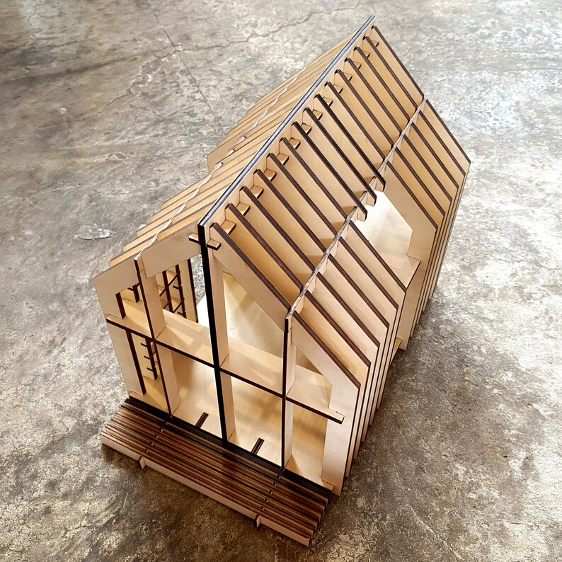 Puede incluir: Un modelo de casa de madera con una estructura de techo detallada y un interior sencillo. El modelo est&aacute; hecho de madera marr&oacute;n claro y tiene un acabado natural.