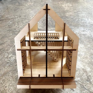 Puede incluir: Un modelo de madera de una iglesia con una cruz en el techo y una escalera en el interior. El modelo est&aacute; hecho de madera clara y tiene un dise&ntilde;o simple.