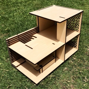 May include: A wooden model of a house with a flat roof and a lattice design on the side. The model is made of light brown wood and has a simple, modern design.