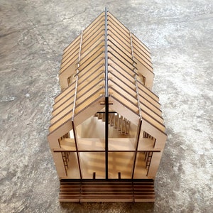 Puede incluir: Un modelo de casa de madera con un techo detallado y un interior sencillo. El modelo est&aacute; hecho de madera marr&oacute;n claro y tiene una base rectangular.
