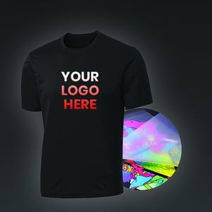 May include: A black t-shirt with the text "YOUR LOGO HERE" printed on the front. The text is in a gradient of red and pink. A sheet of iridescent transfer paper is shown next to the shirt.