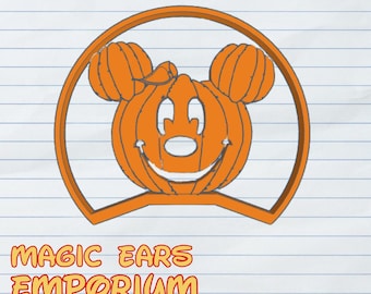 May include: Orange pumpkin-shaped design with Mickey Mouse ears, set within a circular frame. The design has a smiling face and is on a lined paper background. The text "MAGIC EARS EMPORIUM" is below the design.