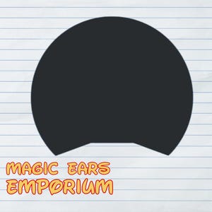 May include: A black, rounded ear shape, likely for a headband, against a lined paper background. The text "MAGIC EARS EMPORIUM" is displayed in orange and yellow, suggesting a theme park or entertainment product.
