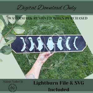 Puede incluir: Un letrero de madera negro con borde dorado presenta recortes de fantasmas azul claro. El letrero incluye el texto "Digital Download Only", "WATERMARK REMOVED WHEN PURCHASED", "Lightburn File & SVG Included" y el logotipo del vendedor.