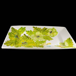 May include: A white rectangular serving platter with a green floral design. The flowers are painted in shades of green and yellow.