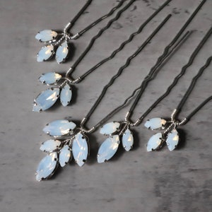 May include: Six silver hair pins with opal-like white crystal accents in the shape of leaves.