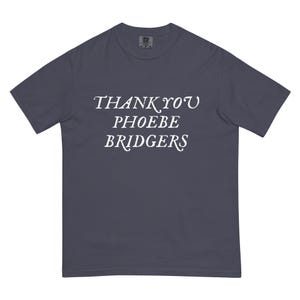 May include: A dark charcoal grey short-sleeved t-shirt featuring the white text THANK YOU PHOEBE BRIDGERS printed in a serif font across the chest. The garment has a crew neckline and a standard fit, with a small brand label visible at the inner neck.