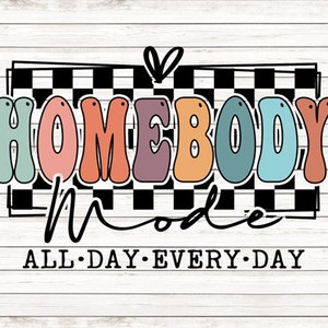May include: A colorful graphic design with the text "Homebody Mode" in a checkered pattern. The text "All Day Every Day" is below the checkered pattern.