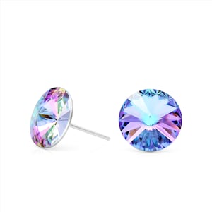 Puede incluir: Un par de pendientes de cristal iridiscente. Los pendientes tienen un diseño redondo y facetado que refleja múltiples colores, incluyendo rosa, morado y azul. Los postes son de color plateado.