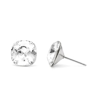May include: A pair of silver stud earrings with clear crystal stones. The stones are round and have a faceted design.