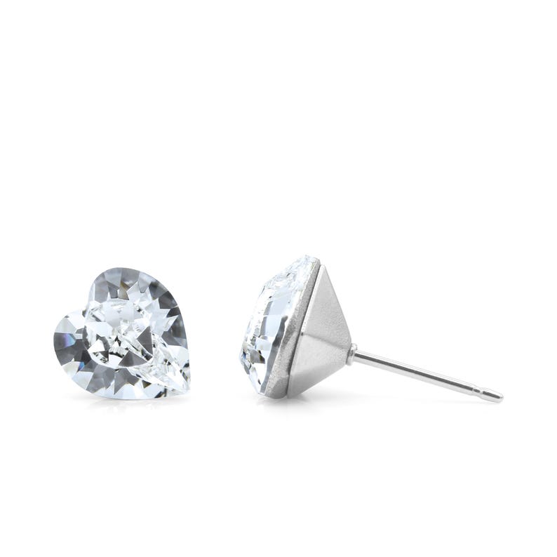May include: A pair of silver stud earrings with clear heart-shaped crystals.
