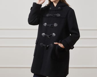 May include: A black hooded duffle coat featuring a front closure with four toggle fasteners, a shoulder yoke, and two large patch pockets. The coat has long sleeves with buttoned cuffs and a hood. The text reads: No Duties for U.S. Orders.