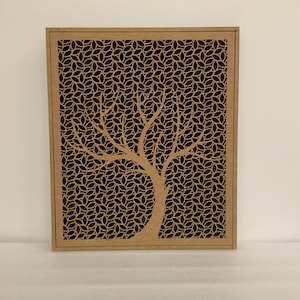 May include: A rectangular wooden wall art piece with a tree design. The tree's trunk and branches are cut out, with a leaf pattern filling the background. The wood has a natural, light brown colour.